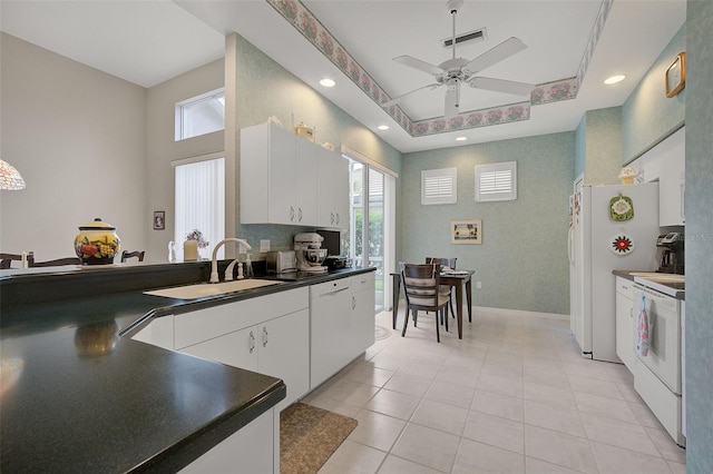 kitchen with ceiling fan, white cabinets, white range oven, and sink