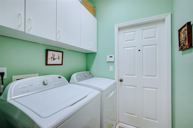 washroom featuring washer and clothes dryer and cabinets