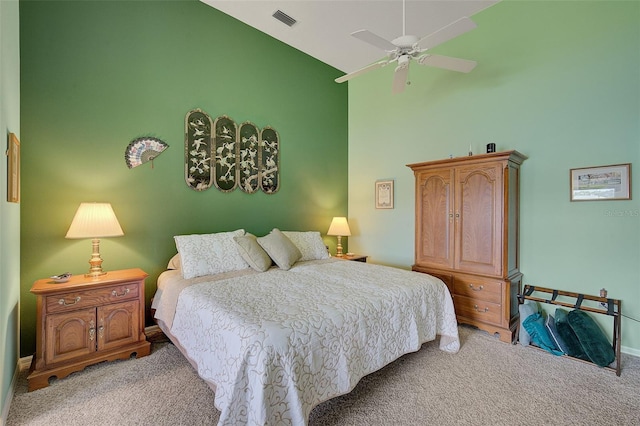 carpeted bedroom with ceiling fan and a towering ceiling