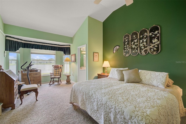 carpeted bedroom featuring high vaulted ceiling, ceiling fan, ensuite bathroom, and a water view