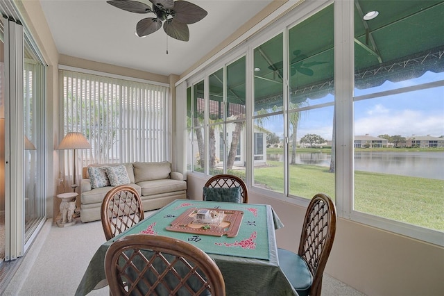 sunroom featuring a water view and ceiling fan