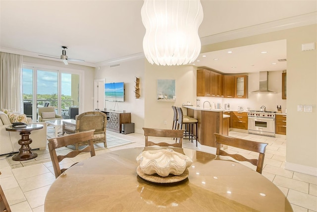 dining room with crown molding, ceiling fan with notable chandelier, and light tile floors