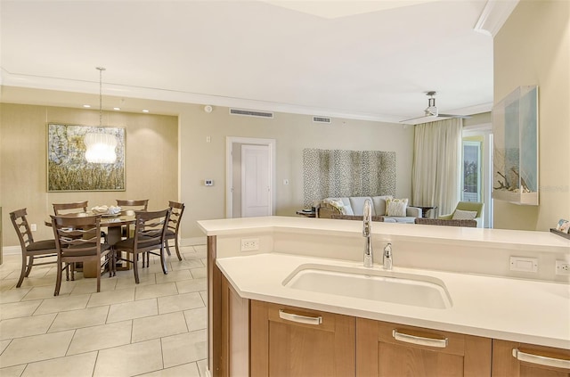 kitchen featuring light tile flooring, an inviting chandelier, sink, pendant lighting, and ornamental molding