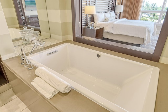 bathroom with a tub and tile flooring