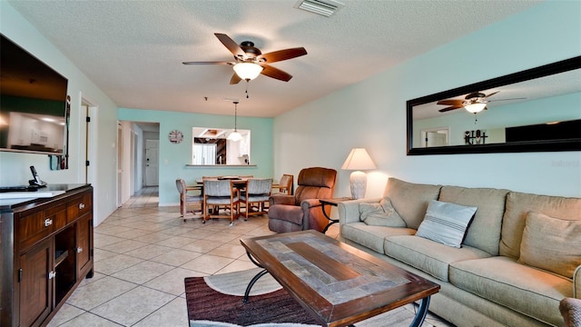 tiled living room featuring ceiling fan and a textured ceiling