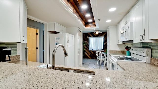 kitchen featuring white appliances, light stone countertops, tasteful backsplash, and ceiling fan