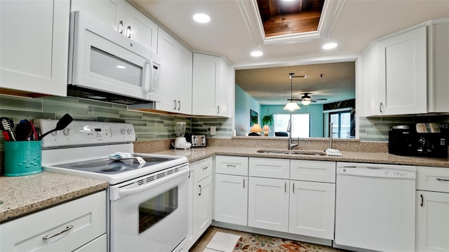 kitchen featuring backsplash, white appliances, ceiling fan, and sink