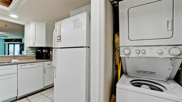 washroom featuring stacked washer / dryer and light tile flooring