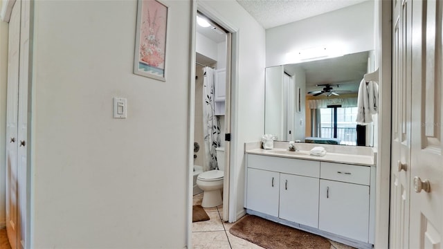 bathroom with ceiling fan, tile flooring, a textured ceiling, toilet, and oversized vanity