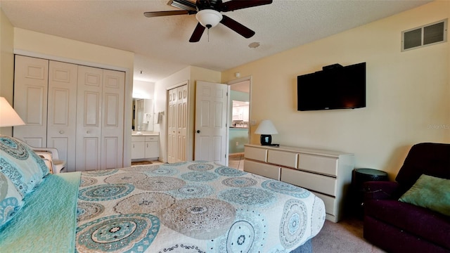 carpeted bedroom featuring connected bathroom, a textured ceiling, and ceiling fan