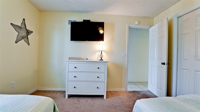 bedroom with light carpet and a textured ceiling