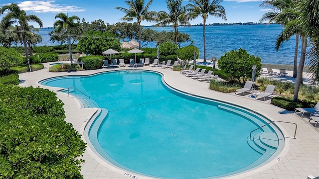 view of pool featuring a water view and a patio area