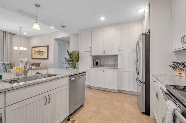 kitchen featuring light stone countertops, sink, white cabinetry, and stainless steel appliances