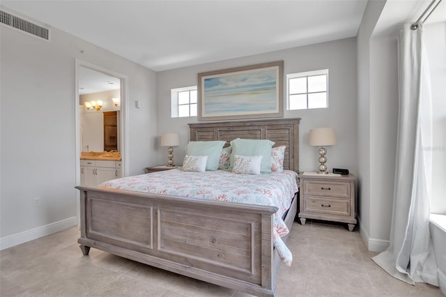 bedroom featuring light tile patterned flooring and ensuite bath