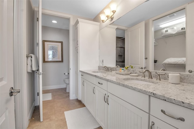 bathroom with tile patterned flooring, vanity, and toilet