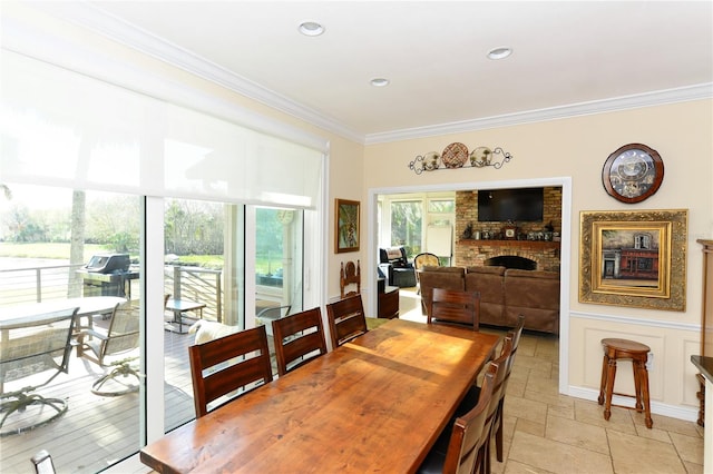 dining area with a fireplace and ornamental molding