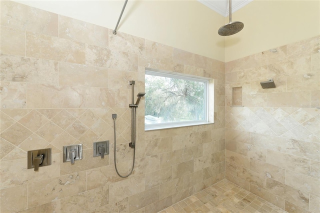 bathroom with crown molding and a tile shower