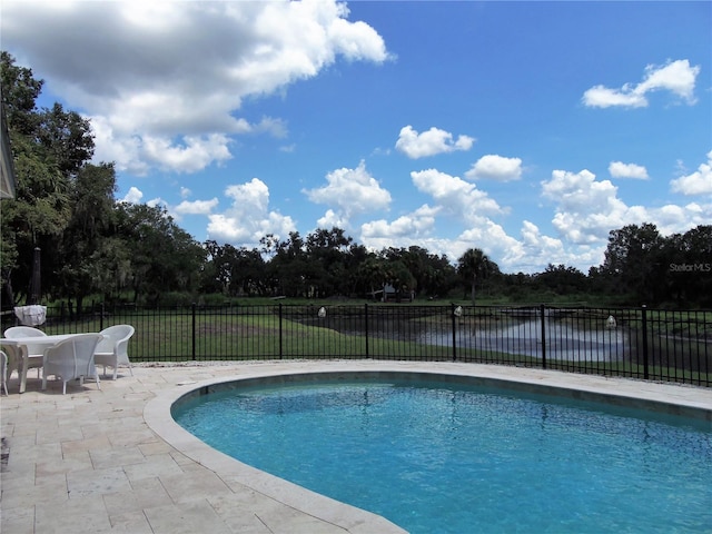 view of pool featuring a water view and a patio area