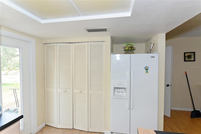 kitchen with white fridge with ice dispenser and light hardwood / wood-style flooring