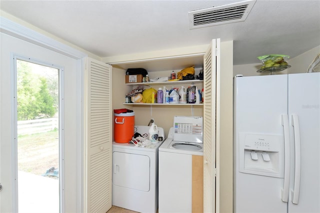 clothes washing area with washer and clothes dryer and a textured ceiling