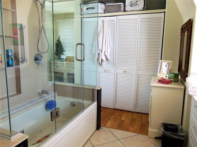 bathroom featuring tile patterned flooring, bath / shower combo with glass door, and vanity