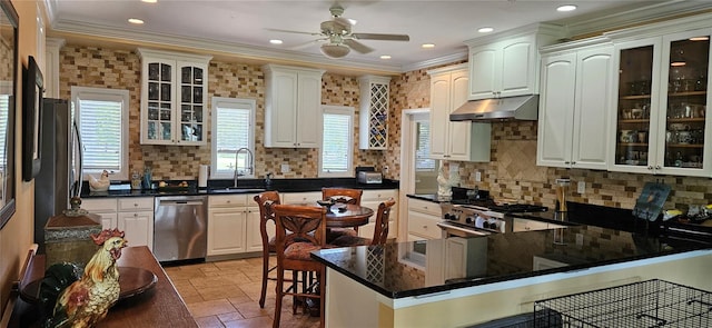 kitchen with sink, stainless steel appliances, a kitchen bar, and a wealth of natural light