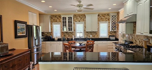 kitchen with ornamental molding, white cabinetry, stainless steel appliances, and tasteful backsplash