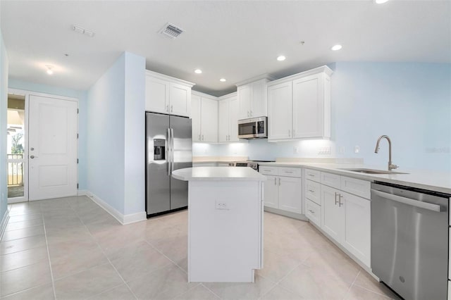 kitchen featuring white cabinets, a kitchen island, sink, and appliances with stainless steel finishes