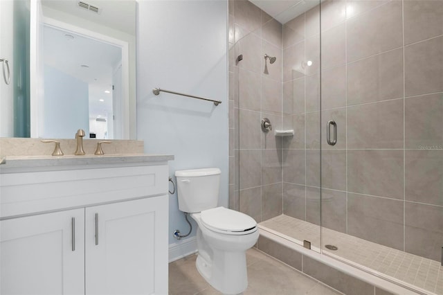 bathroom with tile patterned floors, vanity, toilet, and a shower with door