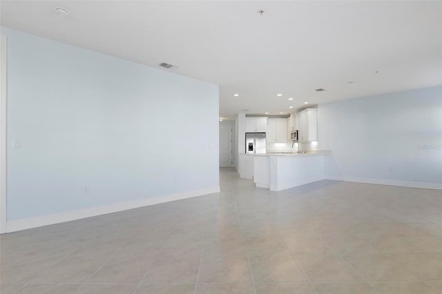 unfurnished living room with light tile patterned floors and sink