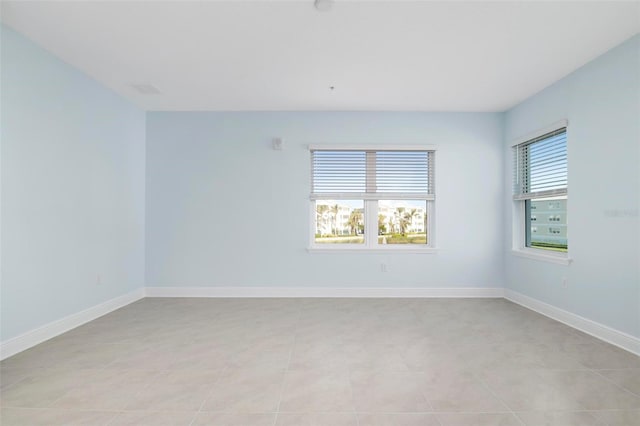 spare room with light tile patterned floors and a healthy amount of sunlight