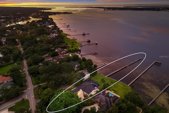 aerial view at dusk featuring a water view