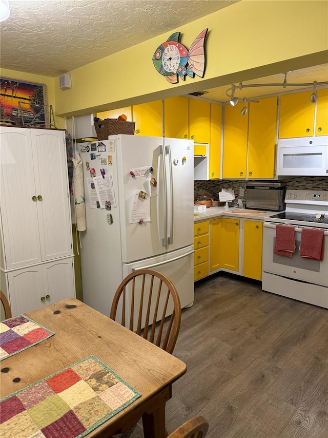 kitchen with backsplash, dark hardwood / wood-style flooring, white appliances, and a textured ceiling