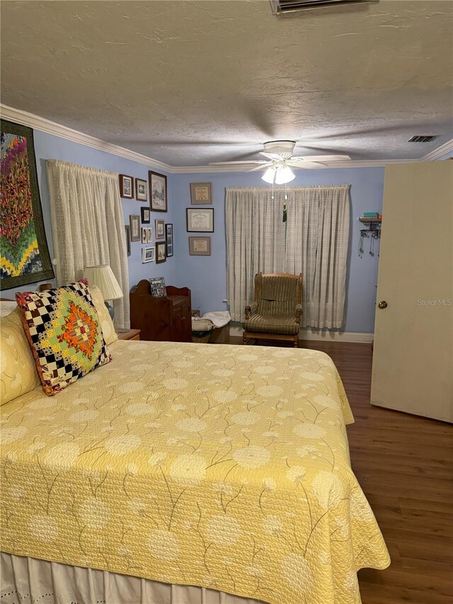 bedroom featuring hardwood / wood-style flooring, ceiling fan, crown molding, and a textured ceiling