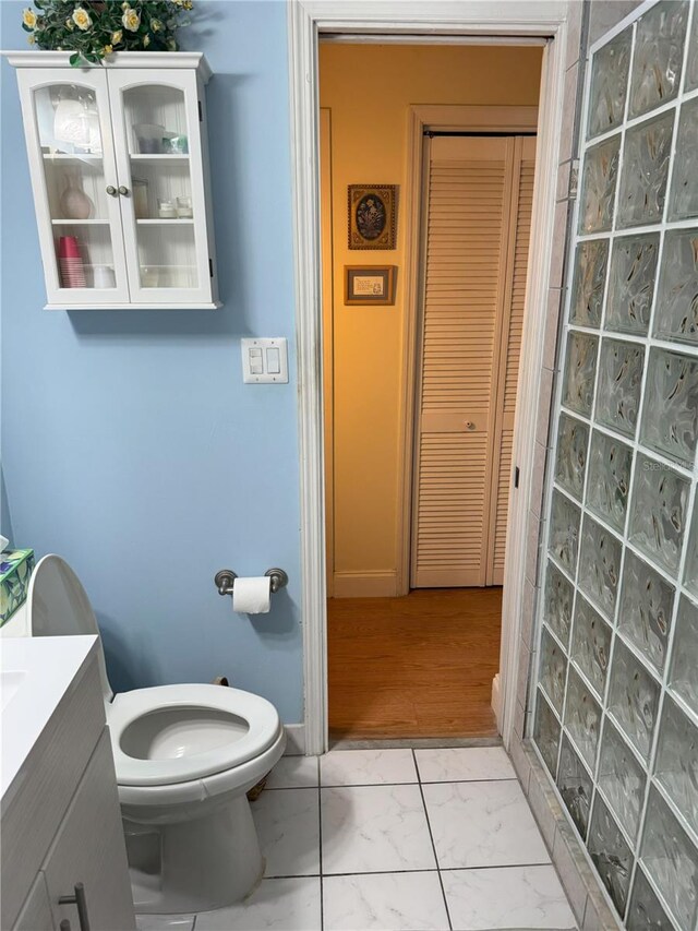 bathroom featuring hardwood / wood-style flooring, vanity, toilet, and walk in shower