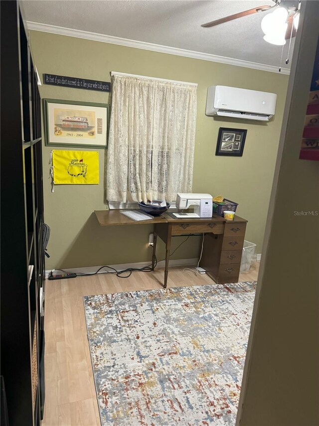 office area with a wall mounted air conditioner, ornamental molding, a textured ceiling, ceiling fan, and hardwood / wood-style flooring