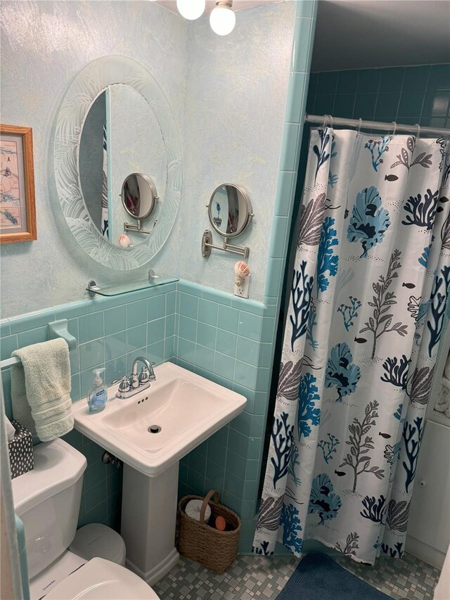 bathroom featuring a shower with curtain, toilet, tile walls, and tile patterned floors