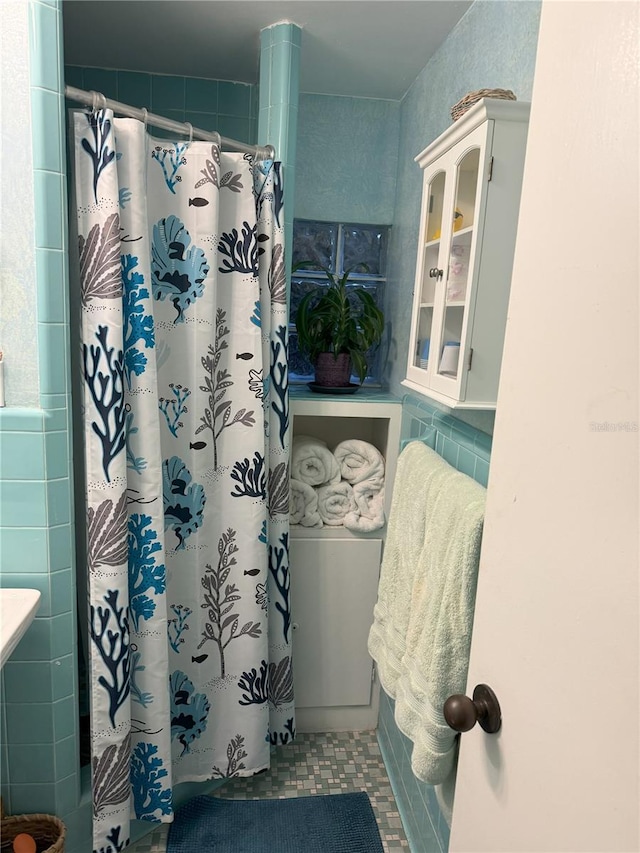 bathroom featuring a shower with curtain, tile patterned flooring, and tile walls