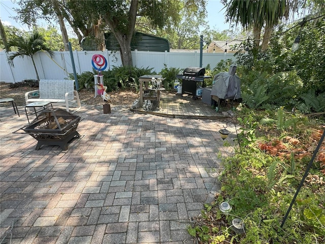 view of patio featuring an outdoor fire pit and a grill