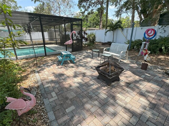 view of patio with a fenced in pool and a fire pit