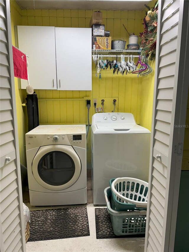 washroom featuring washing machine and clothes dryer and cabinets