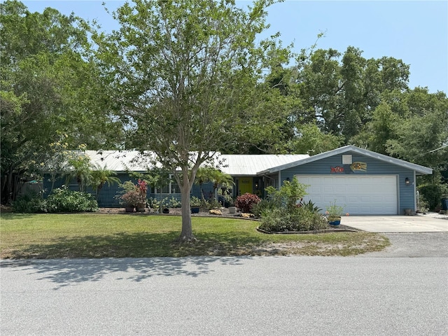 ranch-style home with a garage and a front lawn