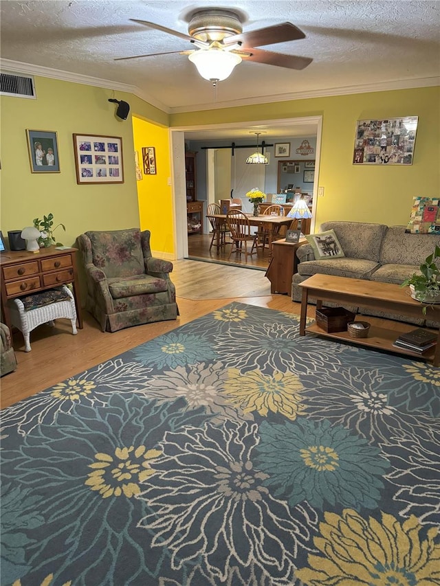 living room featuring hardwood / wood-style floors, a textured ceiling, ceiling fan, and crown molding