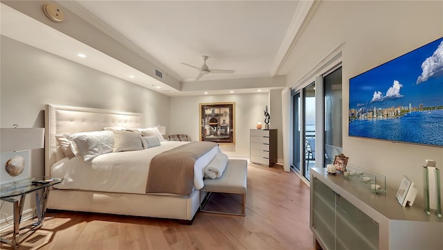 bedroom with a tray ceiling, ceiling fan, light hardwood / wood-style flooring, and access to outside