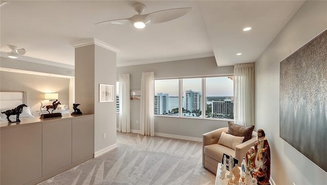 living area with crown molding, light colored carpet, and ceiling fan