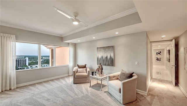 sitting room with crown molding, ceiling fan, and light colored carpet