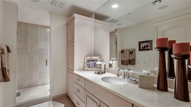 bathroom featuring tile floors, a shower with shower door, and vanity with extensive cabinet space