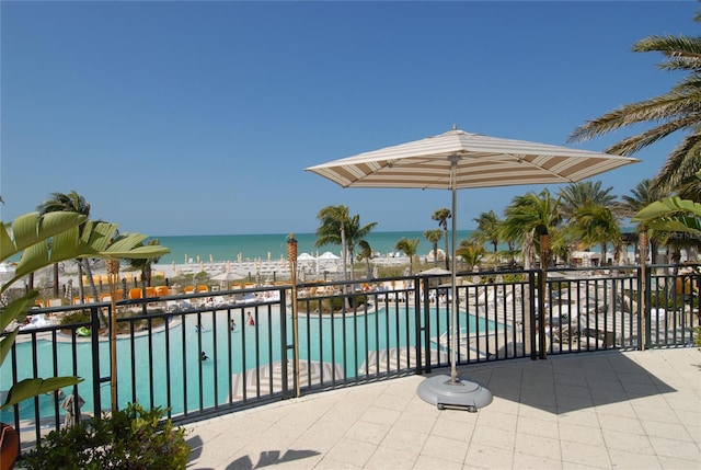 view of swimming pool featuring a patio and a water view