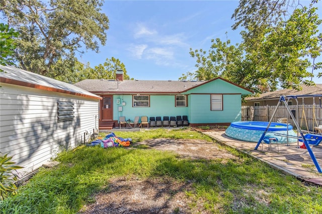 rear view of house with a pool