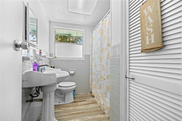 bathroom featuring tile walls, wood-type flooring, and toilet